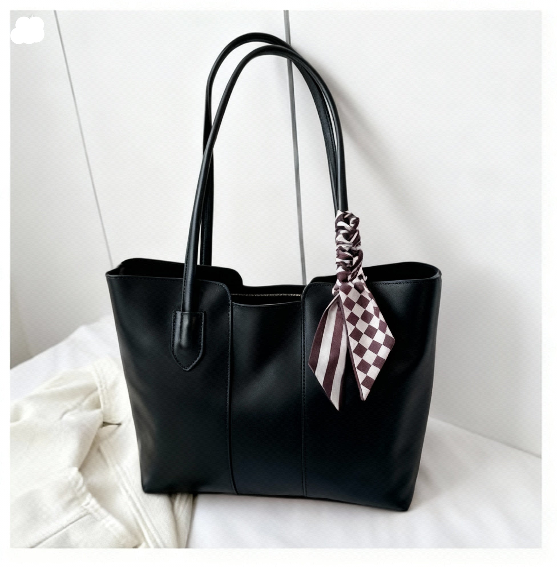 Black tote bag with a checkered scarf on a white background