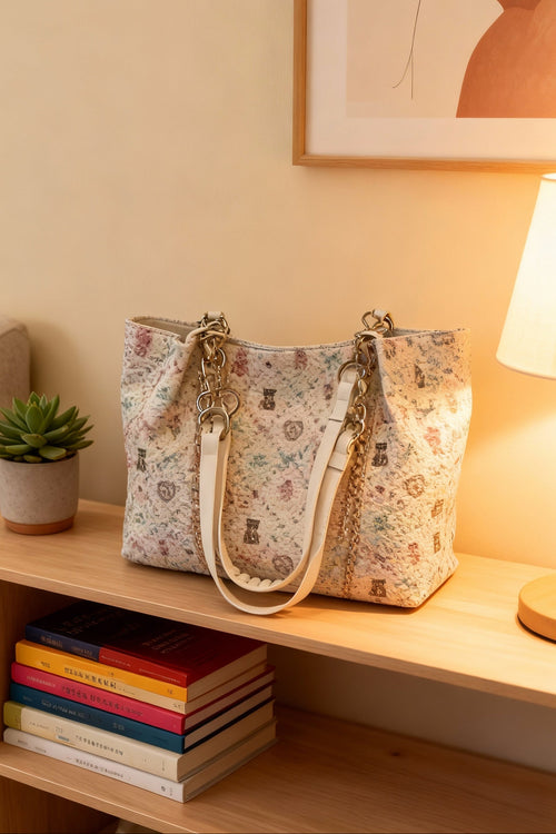 Floral-patterned tote on a wooden shelf with books and a plant